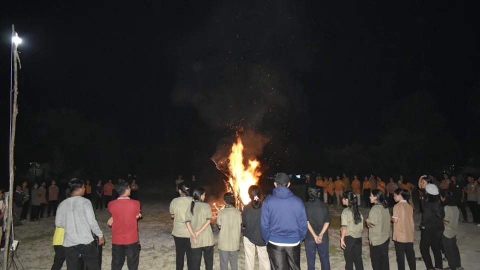 Peserta Ibadah Padang berdiri melingkar di sekitar api unggun