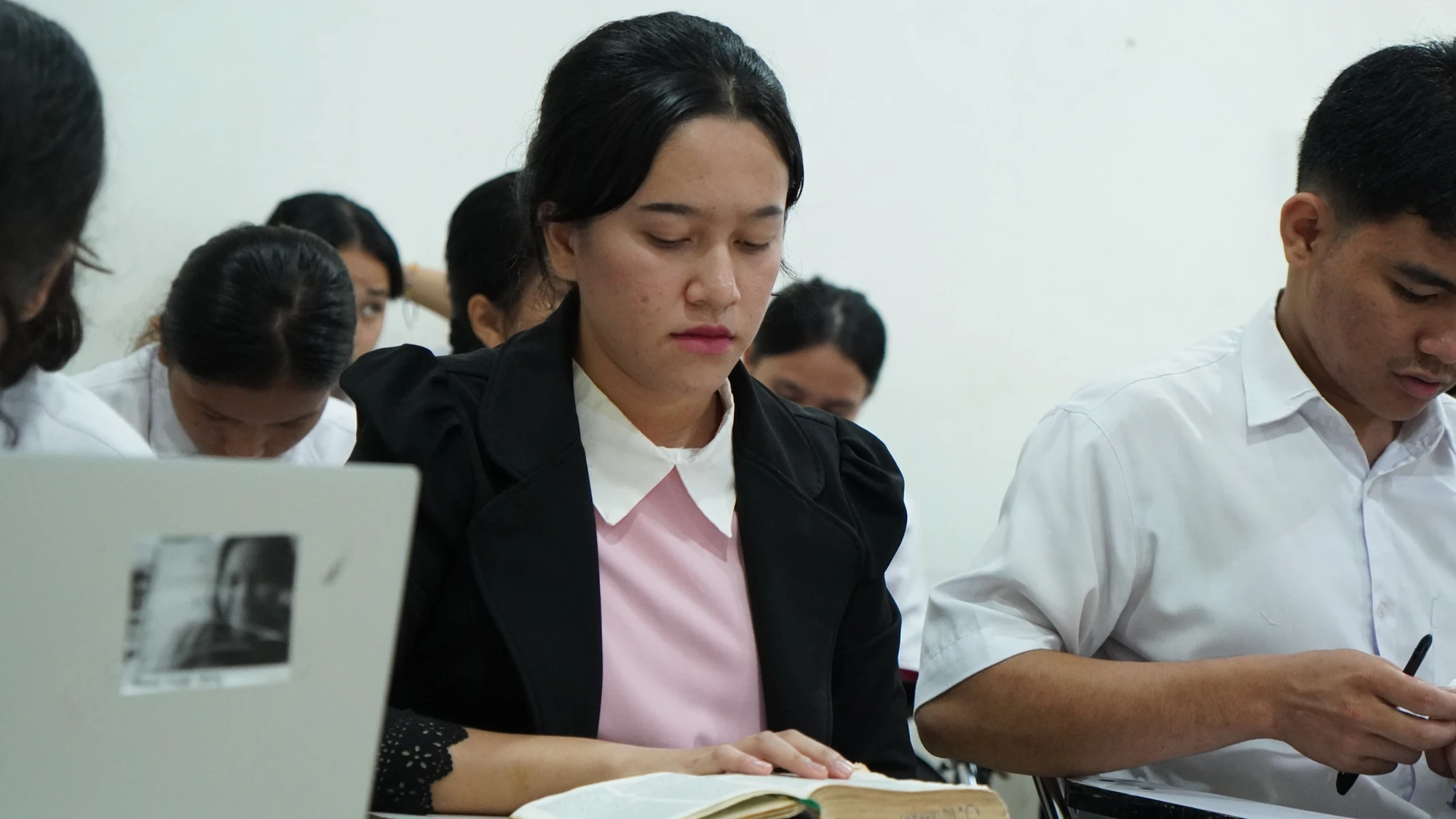 Mahasiswi membaca Alkitab di ruang kelas STT Star Riau